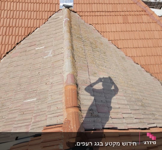 גג רעפים עם צל של אדם מצלם